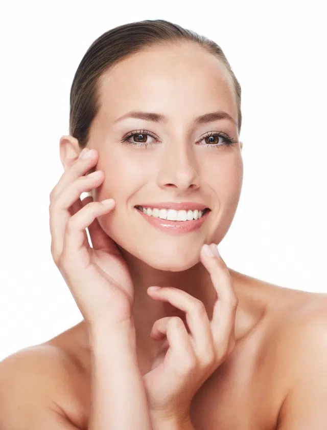 Femme Souriante avec les mains sur le visage injections acide hyaluronique Dr Benjamin Sarfati paris